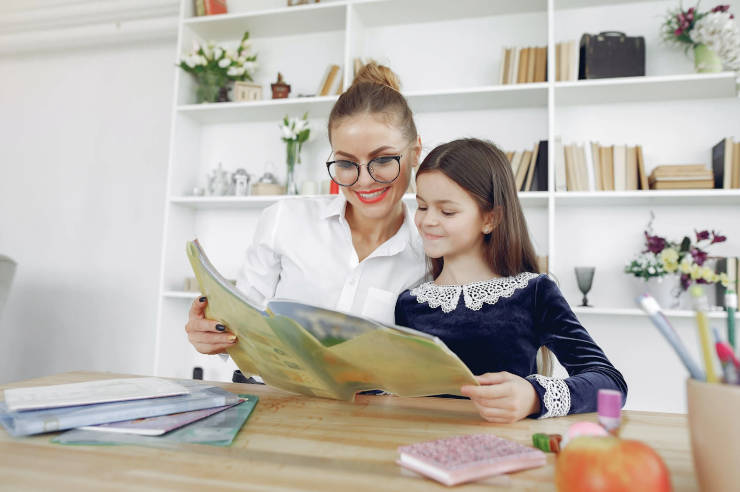 Girl reading together with teacher